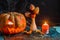 Halloween photo of table with pumpkin, biscuits, dried flowers, burning candle