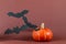 Halloween picture with pumpkin and bat against brown background