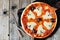 Halloween pizza above scene with decor on rustic wood