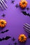 Halloween poster with festive decorations, pumpkins, spiders, skeletons hands, bats on purple background. Flat lay, top view,