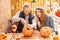 Halloween Preparaton Concept. Young couple sitting at table outdoors making jack-o`-lantern guy carving pumpking while