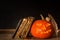 Halloween pumpkin and a book of spells. Carved pumpkin. Magic books. Traditional holiday.