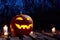 Halloween pumpkin burning in forest at night