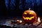 Halloween pumpkin burning in forest at night