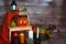 Halloween pumpkin, candles and mushrooms on wood background.