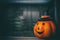 Halloween pumpkin on dark window glass background