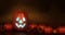 Halloween pumpkin face with a flickering light inside surrounded by ornaments