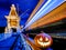 Halloween pumpkin with a glowing grimace at night on the railway bridge. In the background there are rails and blurry