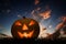 Halloween pumpkin glowing under dark sunset, night sky. Jack o\'lantern