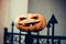 Halloween pumpkin impaled on iron gate