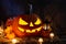 Halloween pumpkin jack lantern in dark barn, holiday concept