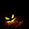 Halloween pumpkin Jack o Lantern glowing at night with blank space above for text