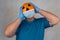 Halloween pumpkin in a medical mask. person with orange evil mask. Jack lantern mask from a basketball