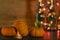 Halloween pumpkin on old wooden background. Warm lights on geen beer botles behind