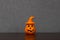 Halloween pumpkin ornament with witch hat centered on wooden shelf