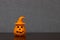 Halloween pumpkin ornament with witch hat placed off-center on shelf