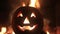 Halloween pumpkin with scary face on fire background.