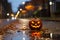a halloween pumpkin sitting on a wet street at night