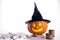 Halloween pumpkin on a white and gray background with candles and foggy smoke. Halloween holiday