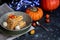 Halloween Pumpkins of bright orange color lie on a dark background, next to red berries.