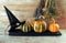 Halloween, pumpkins, witch hat, spiders and bouquets of dry herbs on a wooden table