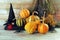 Halloween, pumpkins, witch hat, spiders and bouquets of dry herbs on a wooden table