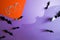 Halloween purple background with bats and word Boo from eyes on orange paper. shadow . top view, copy space