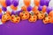 Halloween realistic design. Creepy spooky pumpkin heads with cut out faces and purple, orange, and white balloons.