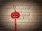 Halloween red pumpkin symbol decoration hanging on white brick wall