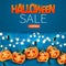 Halloween sale banner or card with scary spooky pumpkin faces and glowing lights garland and spiders over blue background.