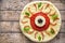 Halloween scary food funny monster eye pizza with mozzarella, basil and tomato sauce