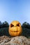 Halloween scary pumpkin with a smile in on a rock
