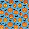 Halloween seamless pattern with orange pumpkins carved faces and black bats on blue background