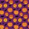 Halloween seamless pattern with orange pumpkins carved faces and black bats on violet background