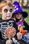 Halloween. Skeleton and witch holding colorful candies