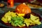 Halloween snack party plate with carved pumpkin, nachos, guacamole and salsa dip