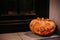 Halloween street decor with spooky Jack-o`-lantern. Pumpkin with scary carved glowing face and candle light in dark, modern