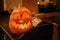 Halloween street decor with spooky Jack-o`-lantern. Pumpkin with scary carved glowing face and candle light in dark, modern