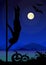 Halloween style silhouette of male pole dancer performing pole moves in front of river and full moon at night .