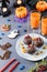 Halloween sweet treats, party food concept. Scary cookies and apples dipped in chocolate