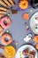 Halloween sweet treats, party food concept. Scary cookies, monster biscuits and fruits on grey background.