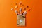 Halloween sweets in paper bag on orange background