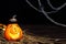 Halloween symbol - glowing Jack o`Lantern pumpkin head with lamp in a pointed black hat in the hay on the background of cobweb
