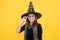 Halloween teen girl in witch hat and glasses look like wizard school pupil, happy halloween