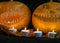 Halloween theme, carved pumpkin with a scary smile, burning candles, spiders and cobwebs, awful skulls, decoration and holiday