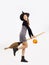 Halloween theme, young asian woman in black dress, boots, witch hat holding broom and carrying orange pumpkin bucket on white