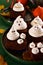Halloween-themed concept: sugar ghosts, pumpkins, coffee on a dark green background. Place for your text.