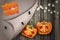 Halloween trick or treat design. Pumpkin heads on wood board plant background.