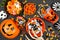 Halloween trick or treat scene with jack o lantern pails and a variety of candy over black