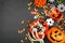 Halloween trick or treat side border with jack o lantern pails and candy on a black background